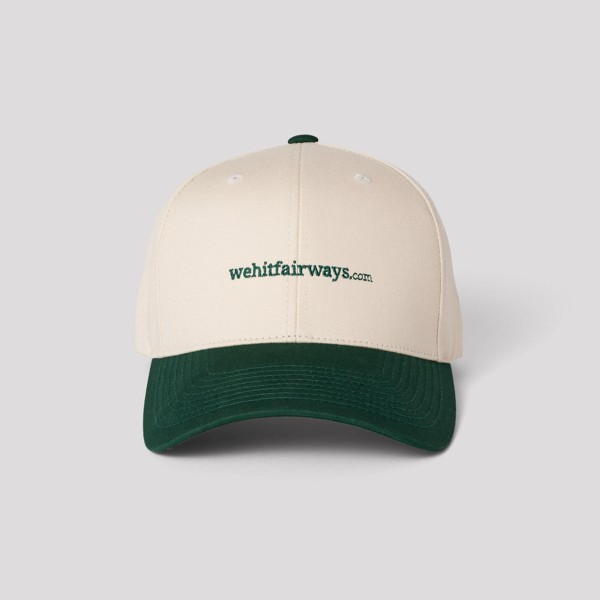 A two-tone golf cap with the 'wehitfairways' logo on the front, featuring a cream crown and a green visor.